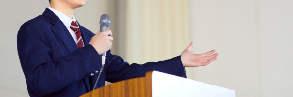 スーツを着た若い男性がプレゼンテーションをしているイメージ