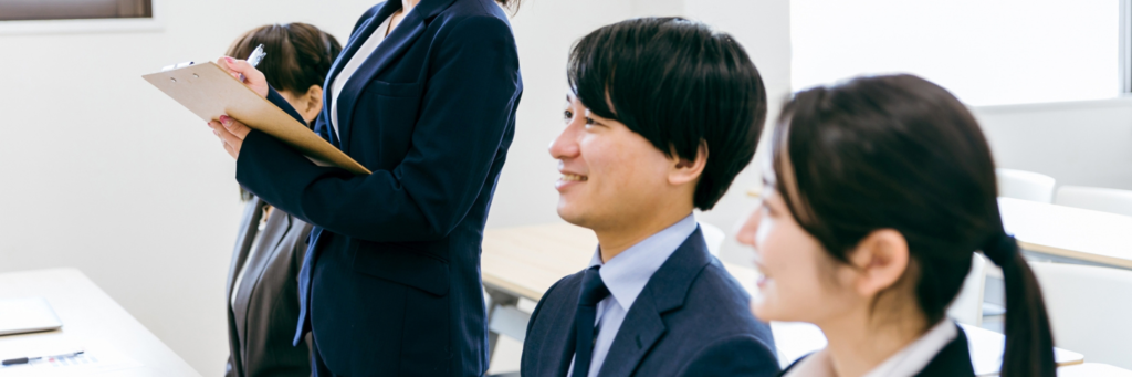 新卒のスーツを着た若者たちが講習を真剣に聞いている