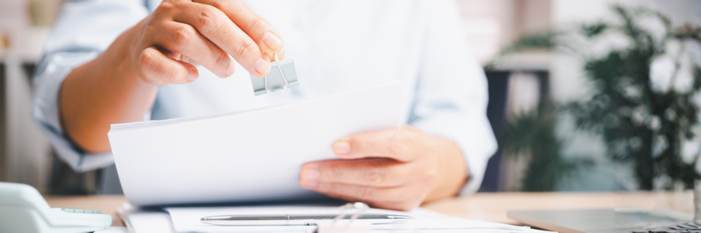 資料をクリップでとめる事務作業をしているイメー時