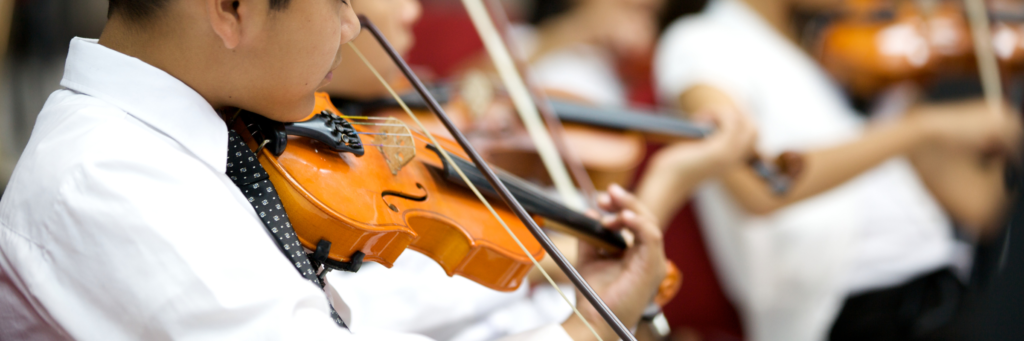 子供が演奏会でバイオリンを弾いているイメージ