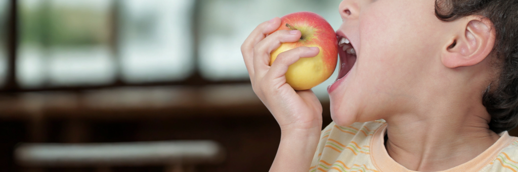 発展途上国で子供がリンゴを食べているイメージ
