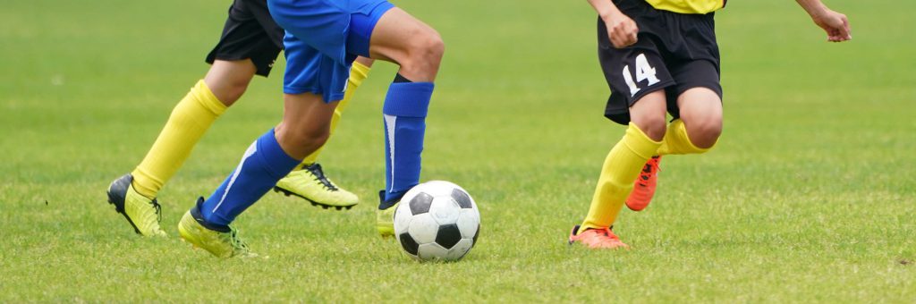 子供がサッカーをしている足元